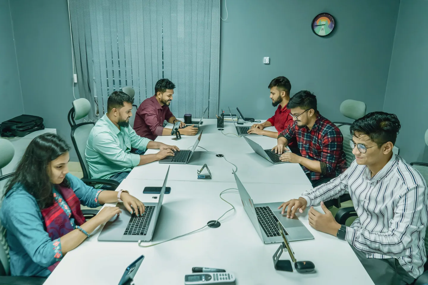Business team reviewing work together on laptop computers